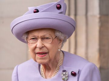 Queen Elizabeth in lila Kostüm schaut ernst 