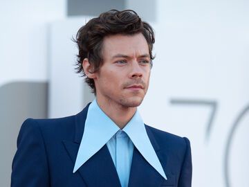 Harry Styles guckt ernst im blauen Anzug