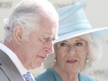 König Charles guckt ernst nach unten und Camilla schaut ihn an