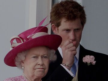Queen Elizabeth II. und Prinz Harry schauen ernst.