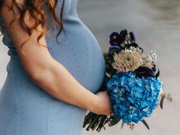schwangere Frau mit Blumenstrauss