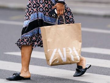 Frau bei Shopping-Tour mit Zara-Einkaufstüte in der Hand 