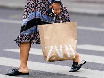Frau bei Shopping-Tour mit Zara-Einkaufstüte in der Hand
