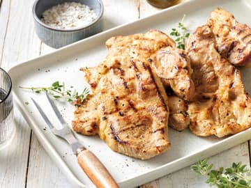 Gegrillte Nackensteaks in Bier-Marinade auf einem Teller