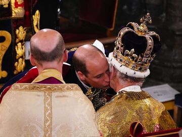 Prinz William gibt König Charles während der Krönung einen Kuss. 