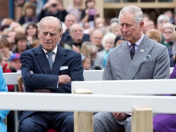 Prinz Philip und König Charles III. sitzen nebeneinander und schauen angespannt