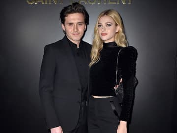 Brooklyn und Nicola Peltz-Beckham posieren vor einer schwarzen Wand