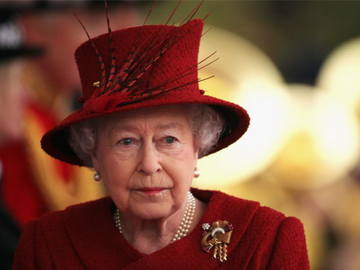 Queen Elizabeth mit rotem Hut schaut ernst 