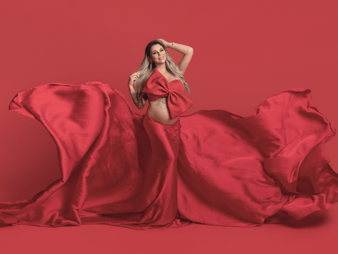 Jenny Frankhauser schwanger mit Babybauch und Schleife im roten Kleid