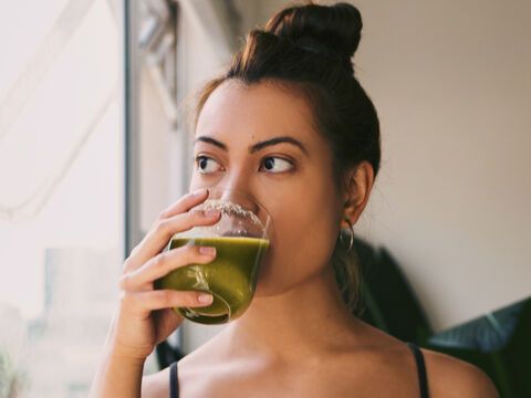 Frau trinkt grünen Drink 