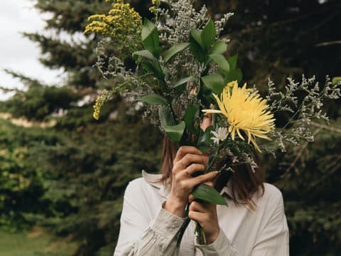 Frau mit Blumen vor Gesicht 