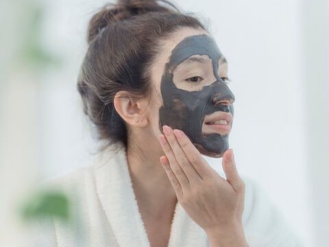 Frau mit schwarzer Anti-Aging-Maske