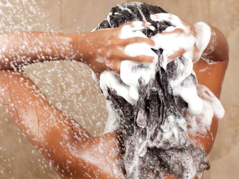Frau wäscht Haare mit Shampoo