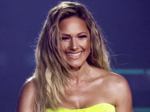 Helene Fischer lächelt mit gelben Oberteil