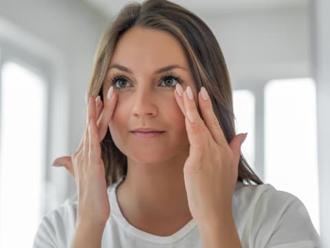 Frau massiert Augen