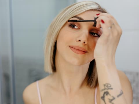 Blondine trägt Mascara auf