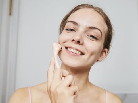 Frau mit einem Beauty-Tool fürs Gesicht 