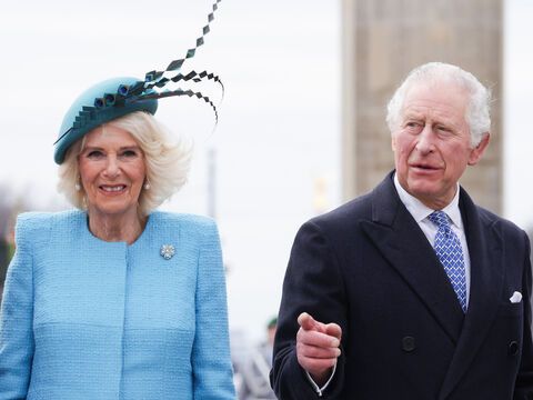 König Charles und Königin Camilla lächeln in Kamera