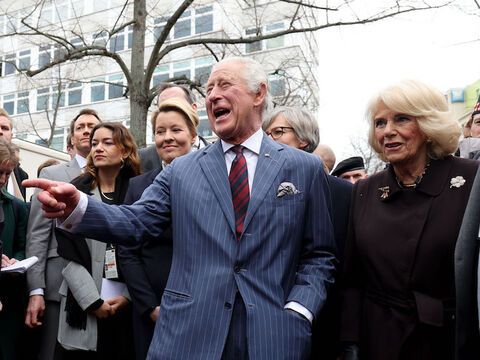König Charles lacht auf dem Berliner Wochenmarkt, neben ihm steht Camilla