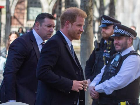 Prinz Harry mit seinem Bodyguard und Polizisten in London