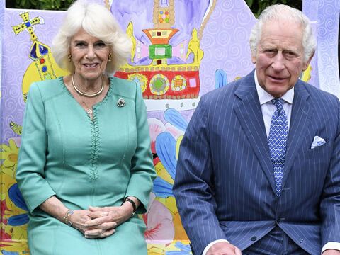 Königin Camilla und König Charles sitzen auf einem nachgebauten Thron.