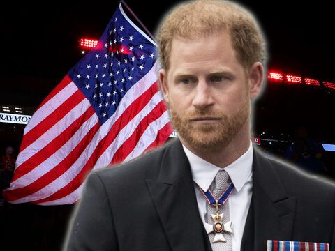 Prinz Harry steht vor einer USA-Flagge, sieht nachdenklich aus