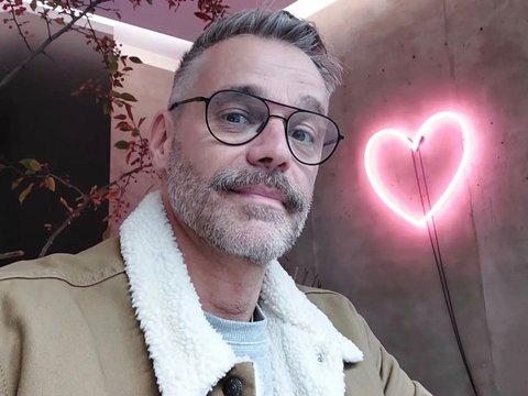 Raphael Schneider macht ein Selfie mit Herzlampe im Hintergrund.
