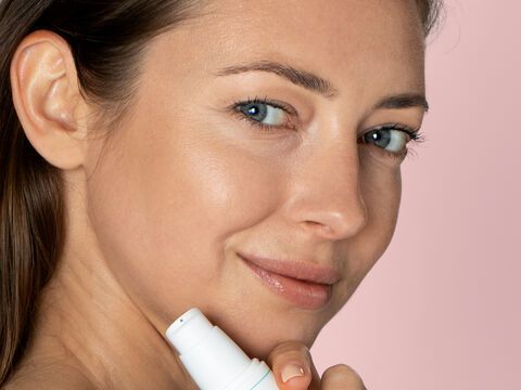 Frau schützt Haut mit antioxidativem Serum
