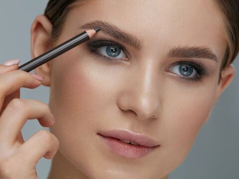 Frau benutzt Produkte für Augenbrauen