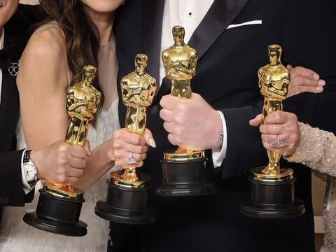 Vier Personen halten Oscar-Preise in den Händen