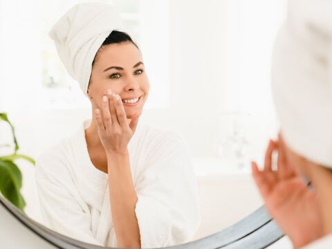 Frau ab 40 pflegt Haut mit Anti-Aging-Creme 
