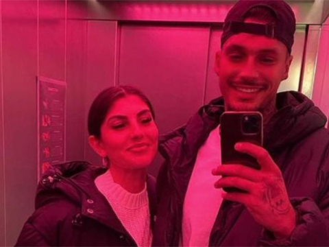 Yeliz Koc und Yasin Mohamed machen ein Spiegelselfie bei rosa Licht