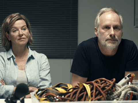 Margarita Broich und Wolfram Koch sitzen an einem Tisch und gucken ernst im Frankfurt Tatort