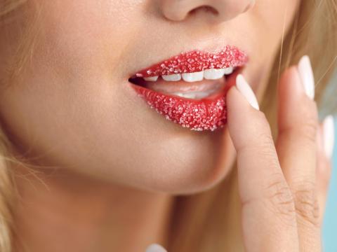 Frau mit Zucker-Peeling auf den Lippen