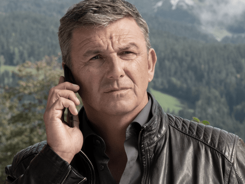 "Der Bergdoktor" Hans Sigl vor Alpen-Panorama - er telefoniert ernst