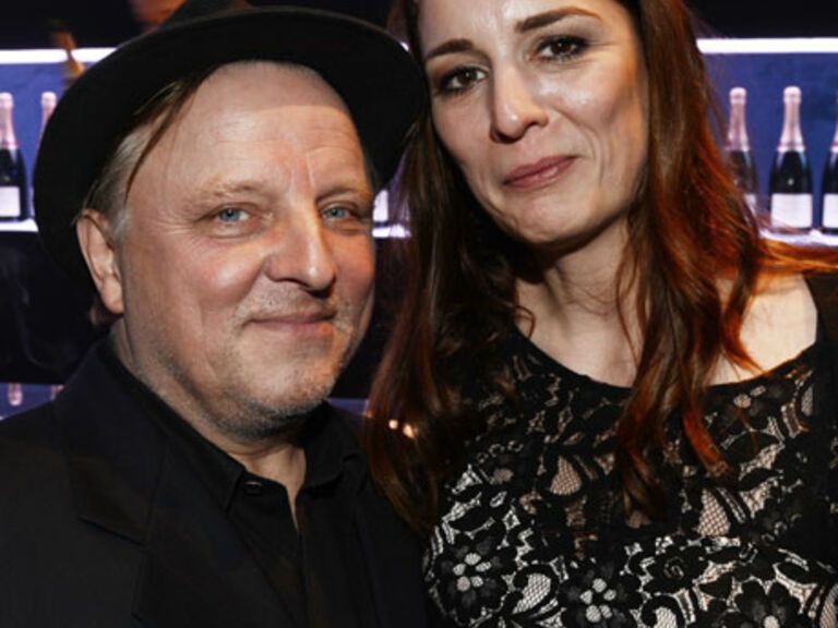 Fluppe in der Hand, Hut auf dem Kopf - und eine echte Lady im Arm: Axel Prahl mit seiner Freundin Silja auf einer Party in Berlin