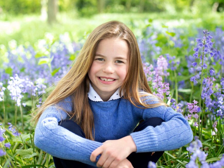 Prinzessin Charlotte sitzt lächeln im Blumenbeet