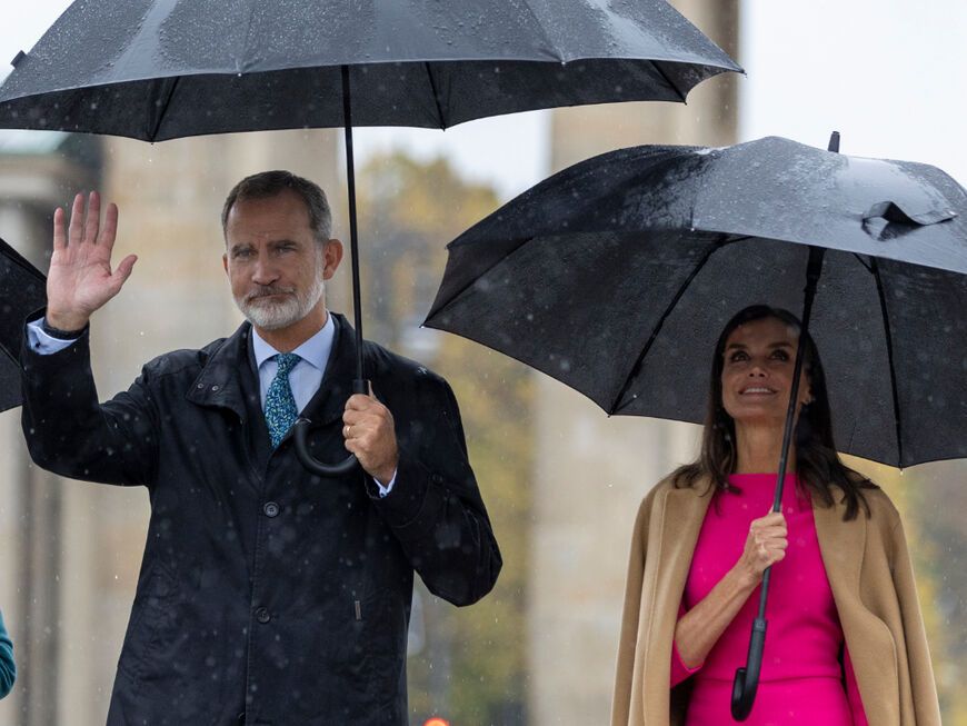 Felipe und Letizia von Spanien mit Regenschirmen vor Brandenburger Tor 