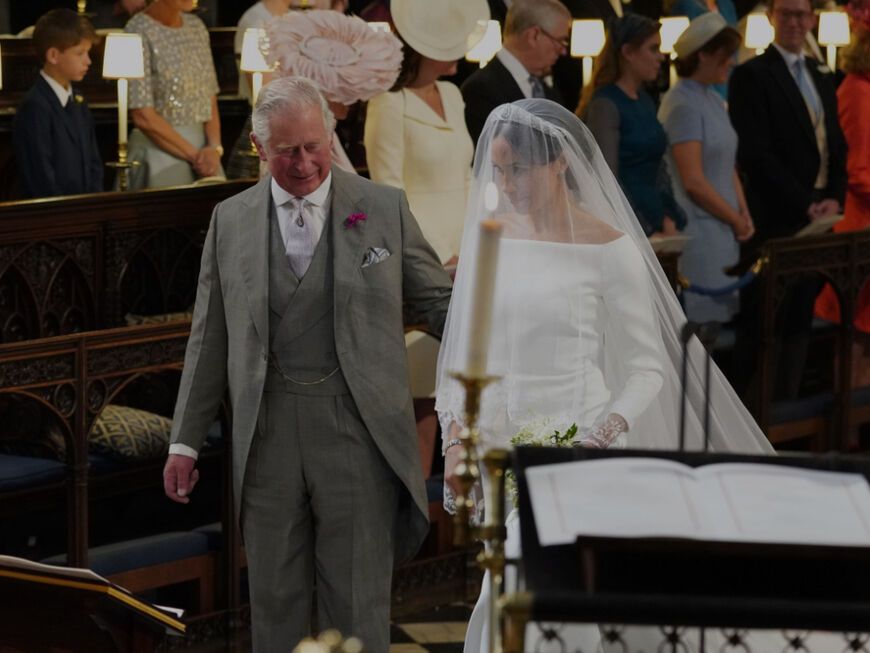 König Charles III. führt Herzogin Meghan zum Altar 2018.