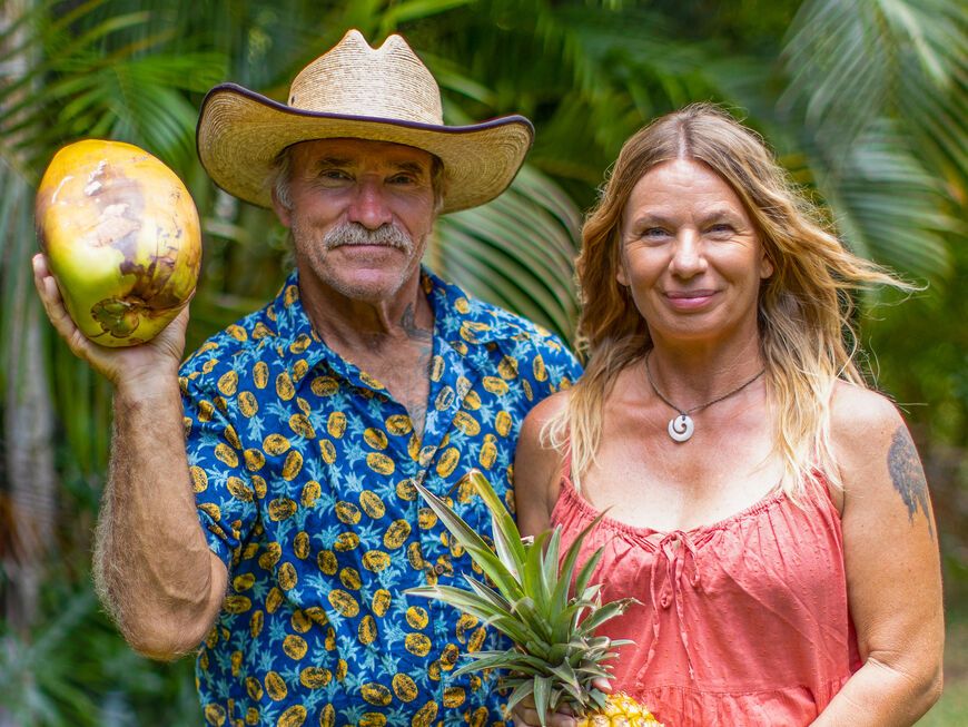 Konny und Manuela Reimann vor Palmenblättern