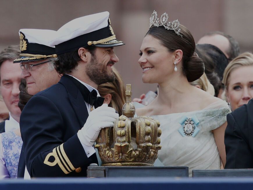 Prinz Carl Philip und Prinzessin Victoria lächeln sich an.