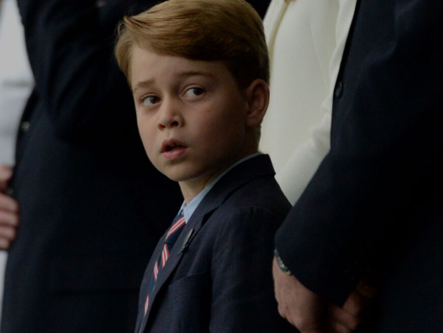 Prinz George steht neben seinen Eltern Prinzessin Kate und Prinz William.