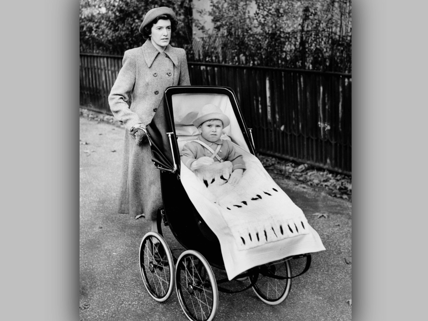 1950: Prinz Charles als Kleinkind an seinem 2. Geburtstag: Seine Nanny schiebt ihn im Kinderwagen durch den Londoner Green Park