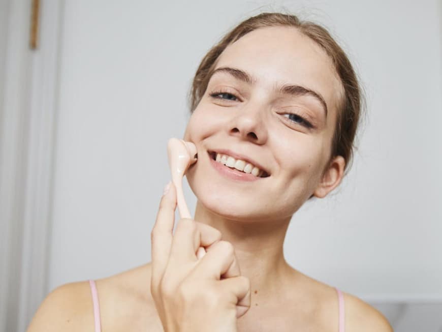 Frau mit einem Beauty-Tool fürs Gesicht