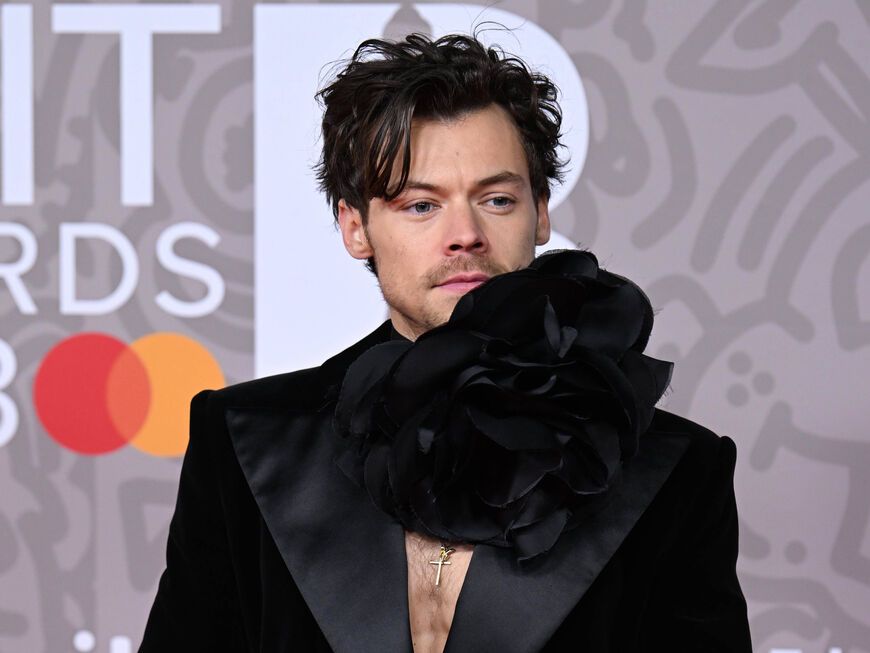 Harry Styles in schwarzem Anzug mit Blume bei den Brit Awards 2023