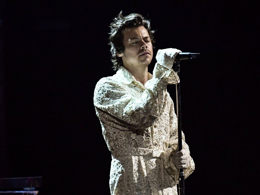 Harry Styles singt mit geschlossenen Augen im weißen Anzug bei den Brit Awards 2020