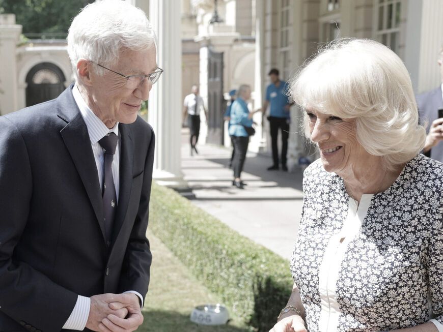 Paul O'Grady und Queen Consort Camilla unterhalten sich und lachen
