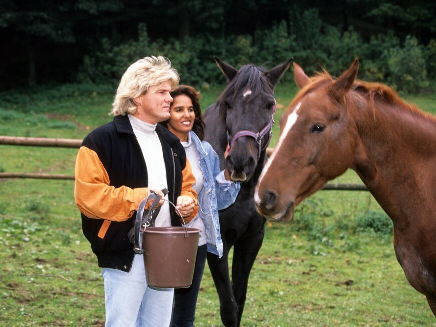 Dieter Bohlen und Nadja abd el Farrag stehen neben Pferden auf einer Wiese