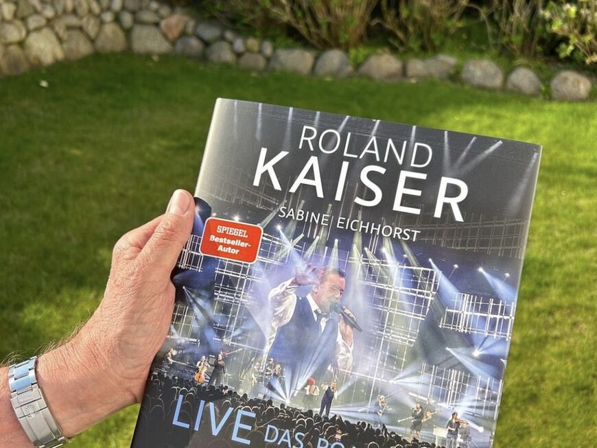 Roland Kaiser hält sein neues Buch Roland Kaiser: Live - Das Roadbook in den Händen