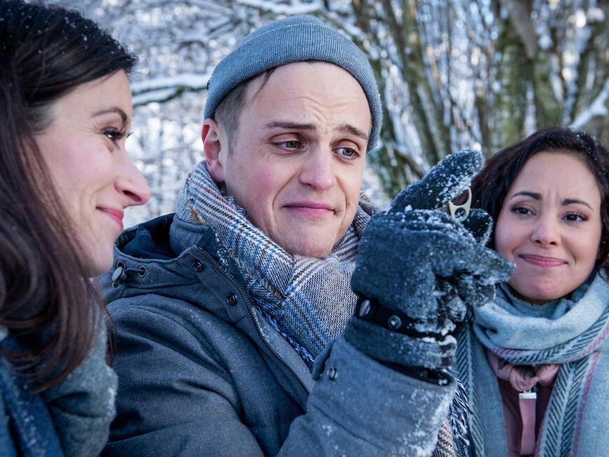 Sturm der Liebe Vanessa, Max und Carolin stehen im Schnee im Wald und gucken auf einen Ring in Max' Hand